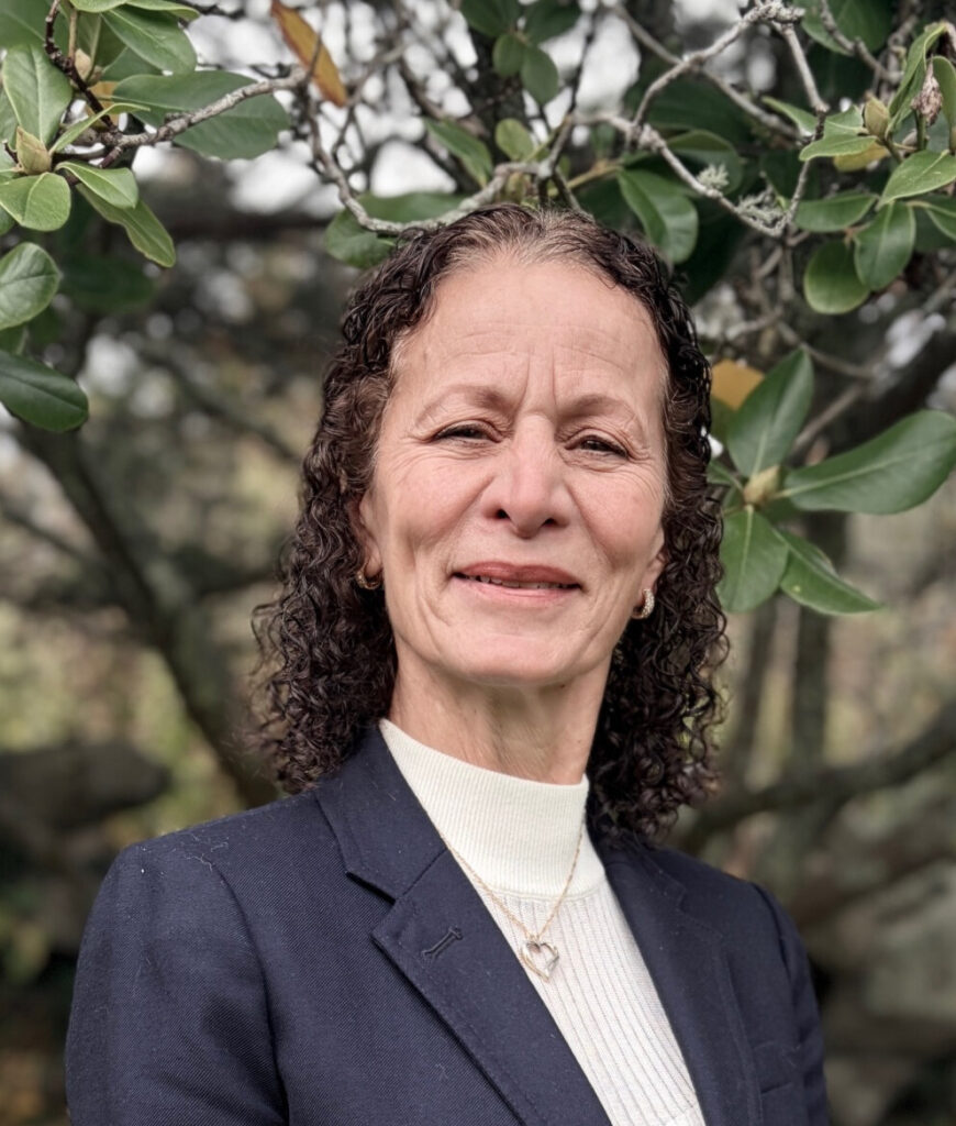 Lisa Nurse standing in front of trees with blue blazer