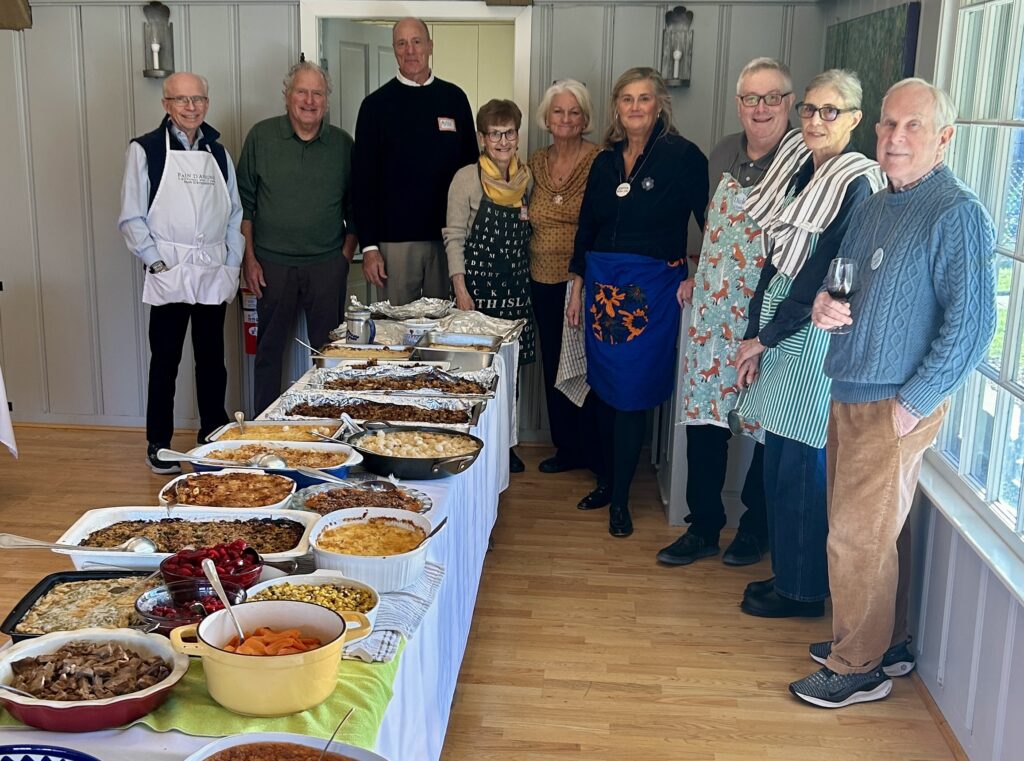 Group of several volunteers posing next to buffet table
